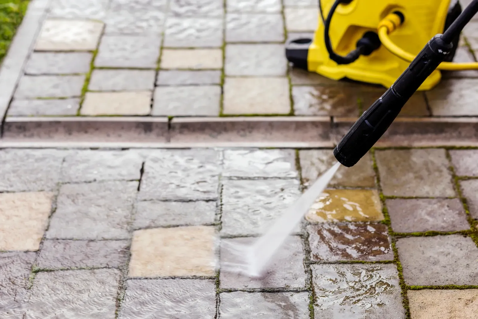 Patio cleaning service pressure washing an outdoor paver surface