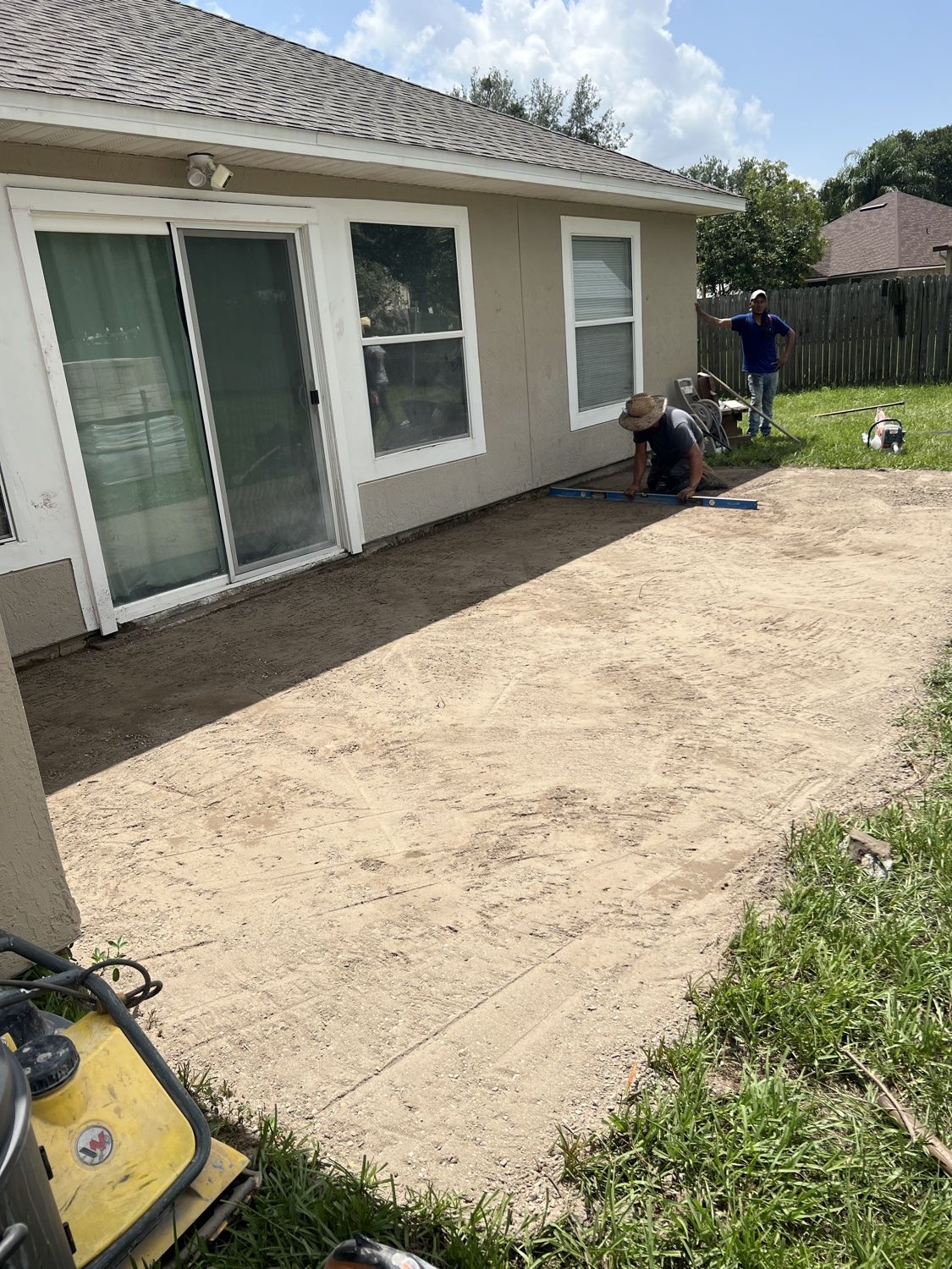 Crew laying patio pavers in the prepared base