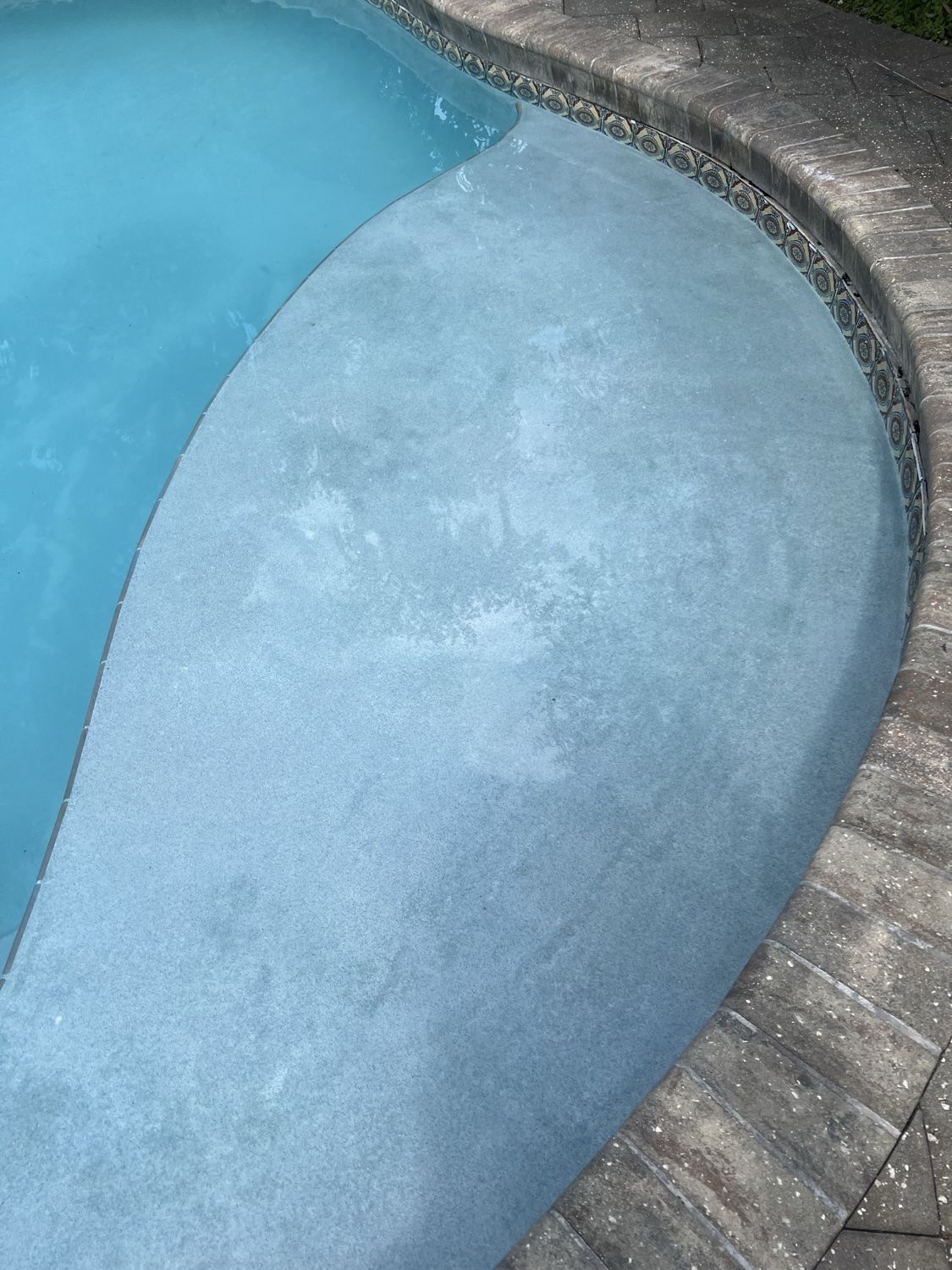 Clean tanning ledge and clear water detail after pool treatment